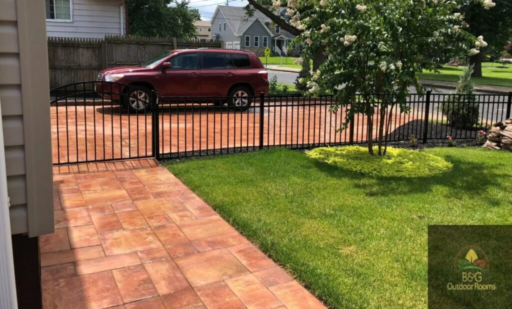 Beautiful paver driveway with car parked on it and with fence nearby